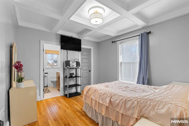 bedroom featuring beam ceiling, ensuite bathroom, and multiple windows