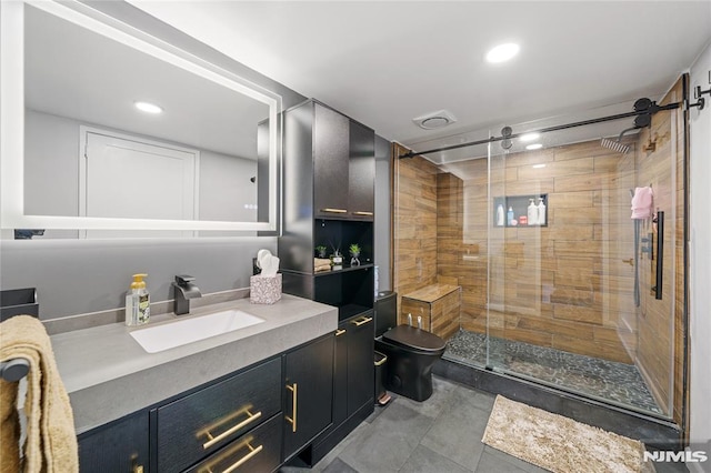 bathroom with toilet, a shower with shower door, and vanity