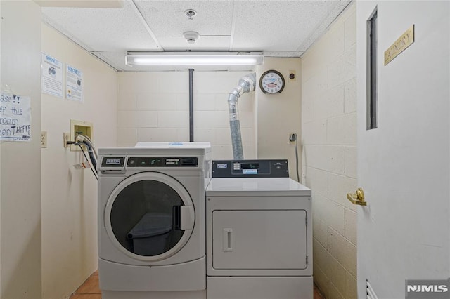 laundry area featuring tile patterned flooring and washing machine and dryer