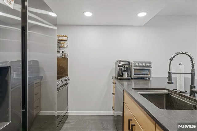 kitchen featuring stainless steel appliances, sink, and light brown cabinetry