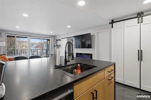 kitchen with sink, white cabinets, a barn door, and dishwasher