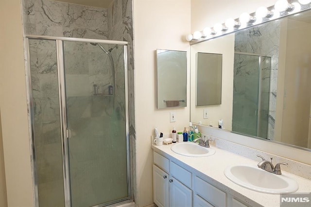 bathroom with a shower with shower door and vanity