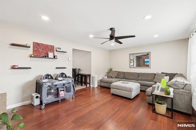 living room featuring ceiling fan and dark hardwood / wood-style flooring