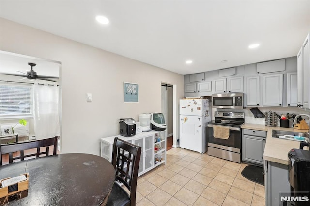 kitchen with ceiling fan, sink, gray cabinetry, and stainless steel appliances