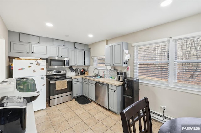 kitchen featuring light tile patterned floors, stainless steel appliances, gray cabinetry, and sink