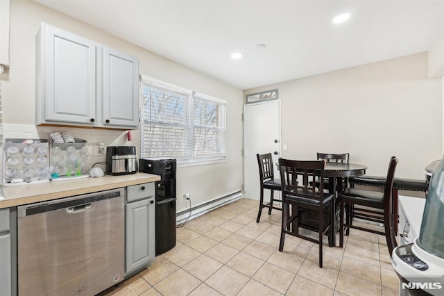 kitchen featuring light tile patterned floors, baseboard heating, stainless steel dishwasher, and gray cabinetry