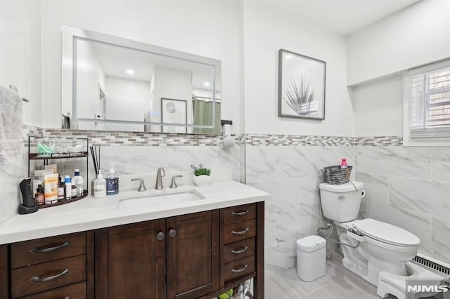 bathroom with toilet, vanity, tile walls, and tile patterned floors