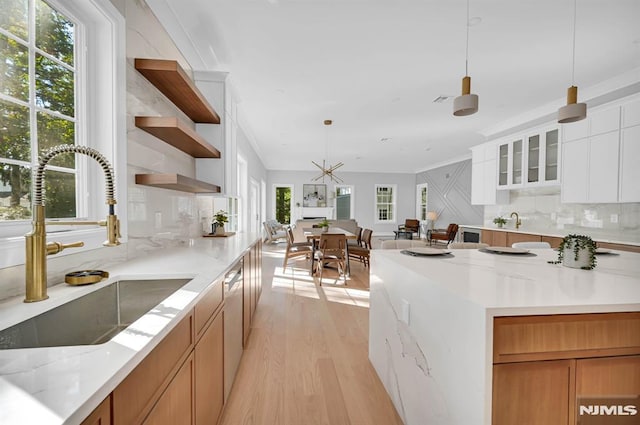 kitchen featuring sink, white cabinetry, decorative light fixtures, and backsplash