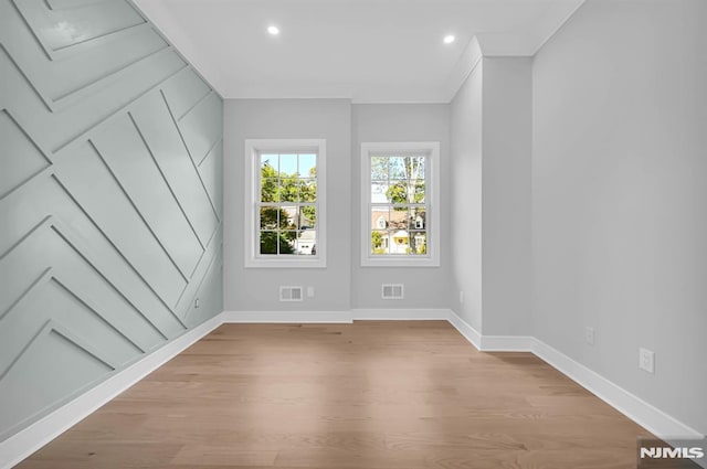 unfurnished room featuring light wood-type flooring and ornamental molding