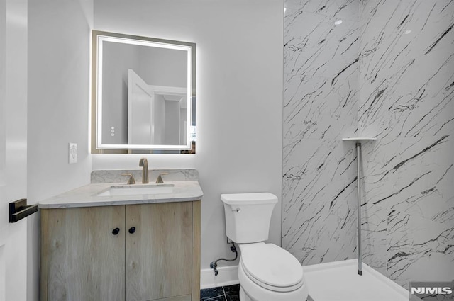 bathroom featuring a shower, vanity, and toilet