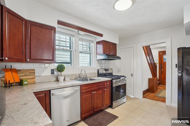 kitchen featuring appliances with stainless steel finishes, decorative backsplash, and sink