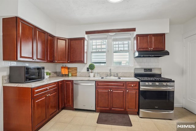 kitchen featuring appliances with stainless steel finishes, tasteful backsplash, and sink