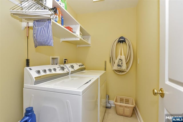 washroom featuring light tile patterned floors and washer and clothes dryer