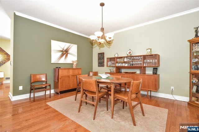 dining space featuring an inviting chandelier, hardwood / wood-style floors, and ornamental molding