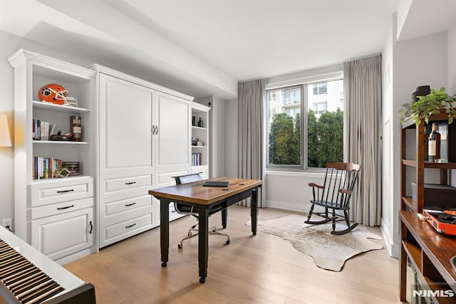 home office with light hardwood / wood-style flooring