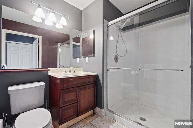 bathroom with toilet, walk in shower, and vanity