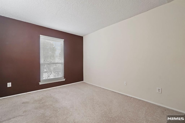 carpeted spare room featuring a textured ceiling