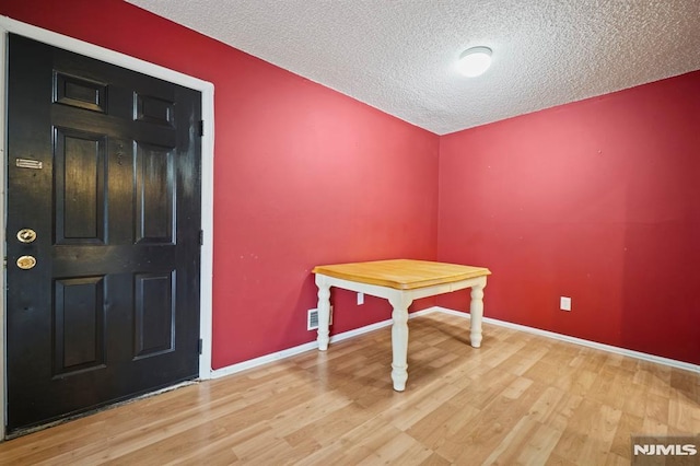 interior space featuring a textured ceiling and light hardwood / wood-style floors