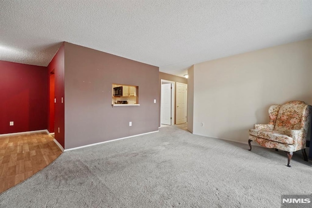 interior space with a textured ceiling and carpet flooring