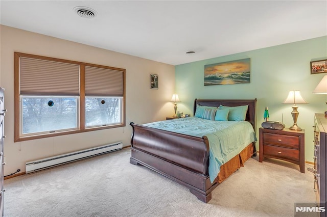 bedroom with a baseboard heating unit and light carpet