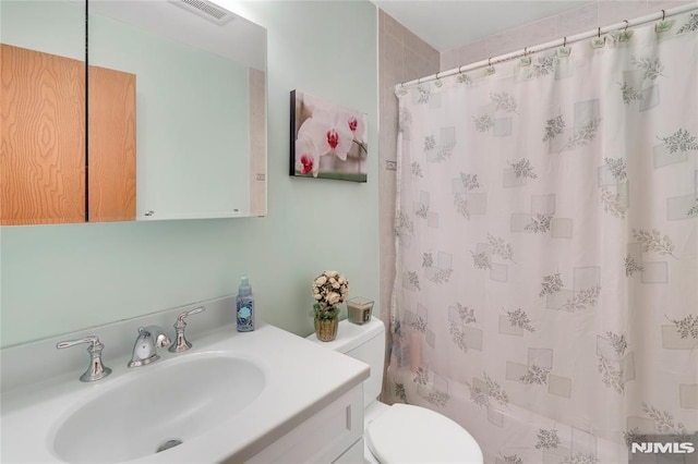 full bathroom with toilet, vanity, and shower / bathtub combination with curtain