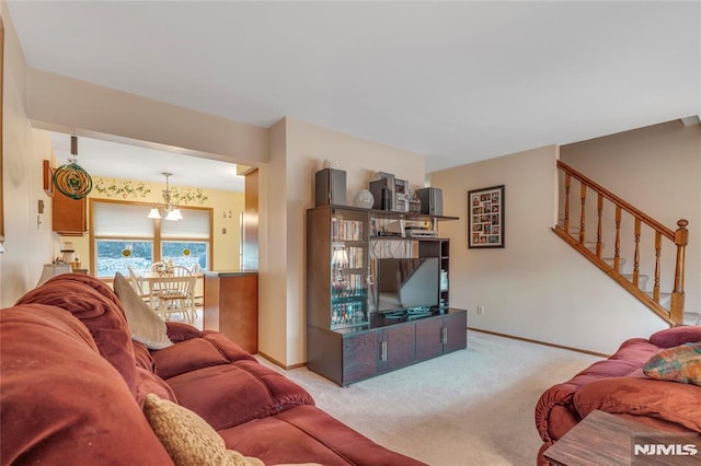 carpeted living room with a notable chandelier