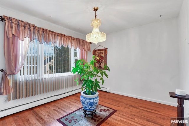 living area featuring a baseboard heating unit, hardwood / wood-style flooring, and a chandelier