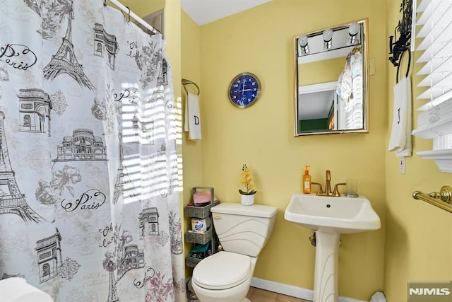 bathroom featuring toilet and a shower with shower curtain