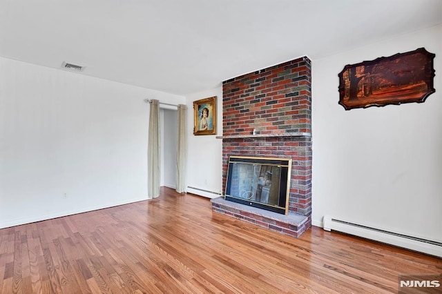 unfurnished living room with a baseboard radiator, a fireplace, and light hardwood / wood-style floors