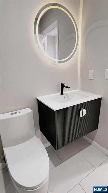 bathroom featuring tile patterned floors, vanity, and toilet