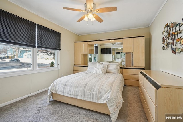 bedroom with ceiling fan, crown molding, and light colored carpet