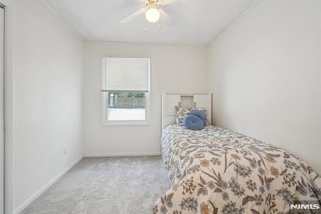 bedroom with ceiling fan, crown molding, and light carpet