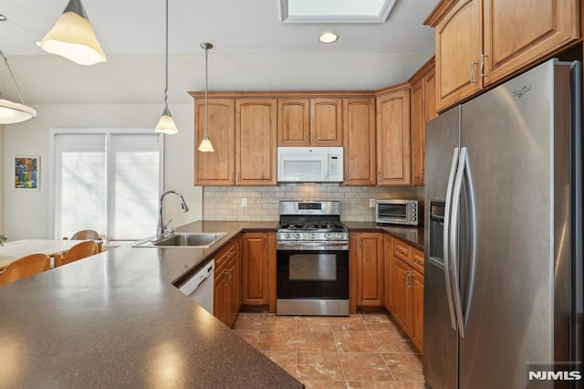 kitchen featuring stainless steel appliances, backsplash, pendant lighting, and sink