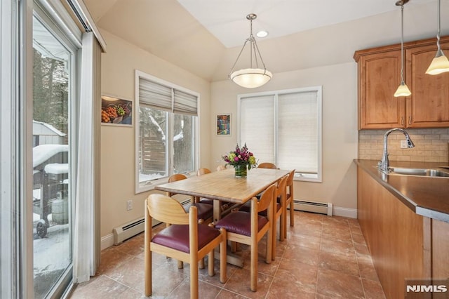 dining area with lofted ceiling, a baseboard radiator, and sink