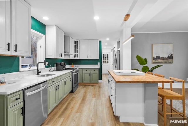 kitchen featuring sink, green cabinetry, white cabinets, and appliances with stainless steel finishes