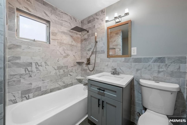 full bathroom featuring toilet, vanity, tile walls, and tiled shower / bath