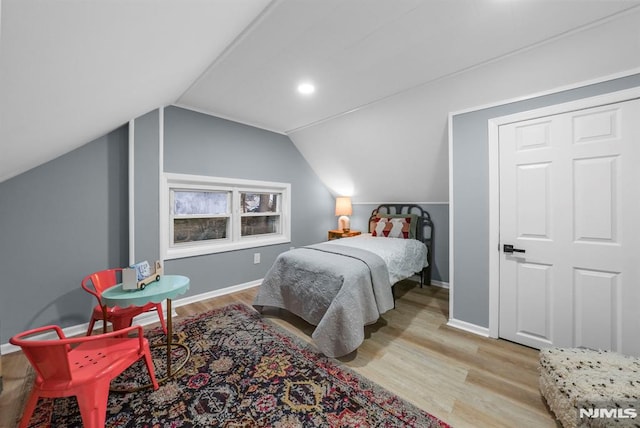 bedroom featuring light hardwood / wood-style floors and lofted ceiling