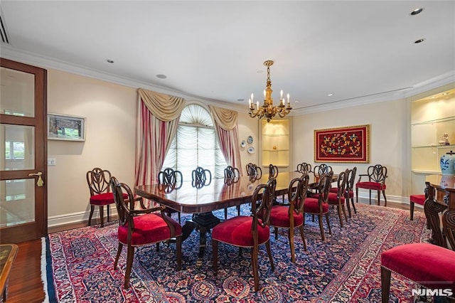 dining area featuring crown molding, wood-type flooring, and a notable chandelier