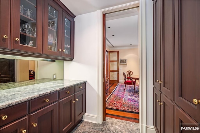 bar featuring crown molding and light stone countertops