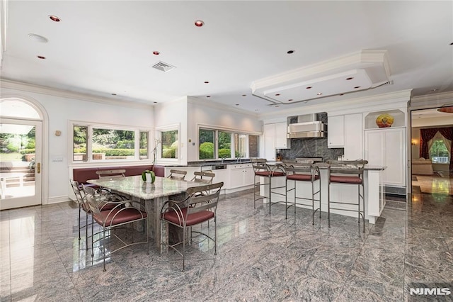 dining space with a wealth of natural light and ornamental molding