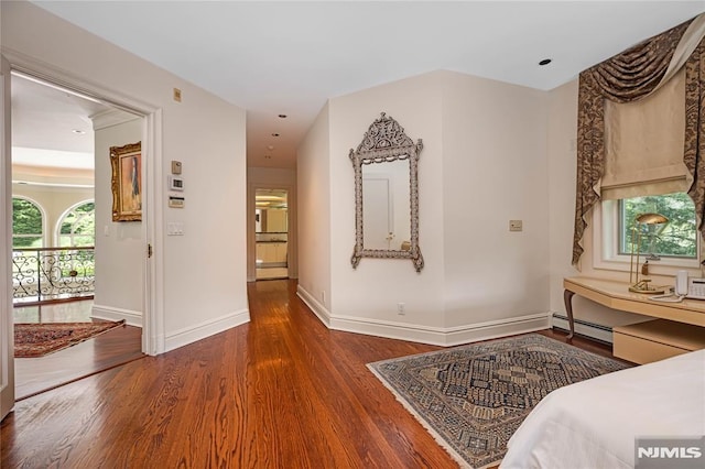 hall featuring baseboard heating and dark hardwood / wood-style flooring