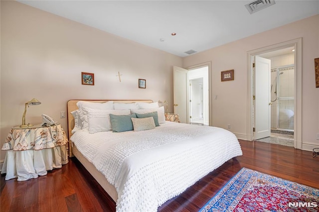 bedroom with ensuite bathroom and dark hardwood / wood-style floors