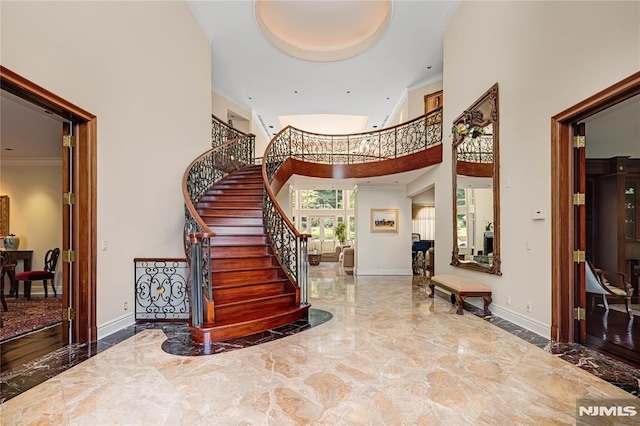 foyer featuring ornamental molding and a high ceiling