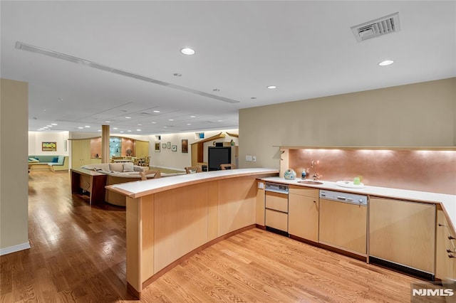 kitchen featuring light hardwood / wood-style floors, dishwashing machine, light brown cabinets, and kitchen peninsula