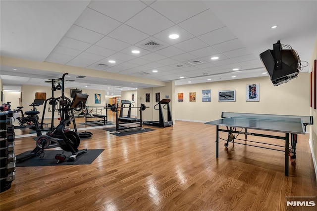 workout area with a drop ceiling and hardwood / wood-style floors