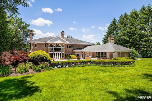 back of property featuring a lawn, a patio area, and a balcony