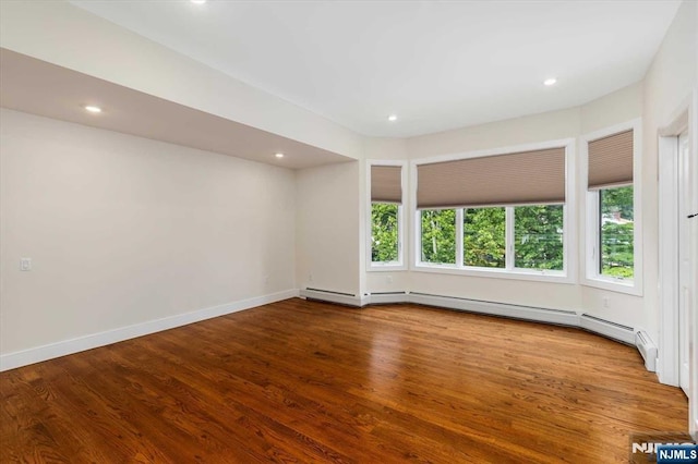 spare room with recessed lighting, baseboards, and wood finished floors