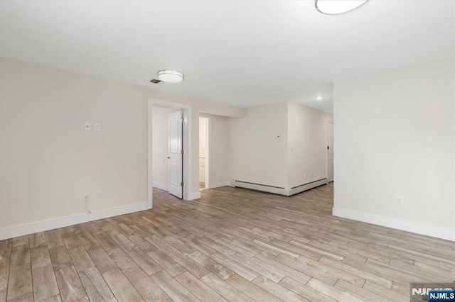 spare room featuring light wood-style floors, recessed lighting, baseboards, and baseboard heating