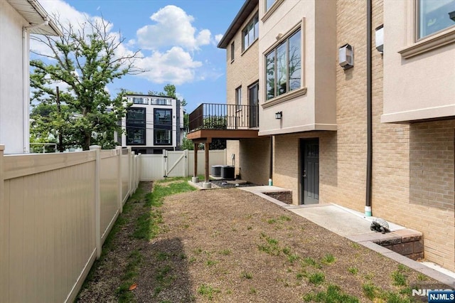 view of yard with a fenced backyard, a gate, and central air condition unit
