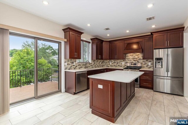 kitchen featuring visible vents, light countertops, premium range hood, and stainless steel appliances